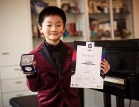 Maximilian Zhu mit Urkunde und Medaille