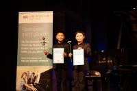 Maximilian Hongchen Zhu und Yishi Huang mit Urkunden und einer Rose